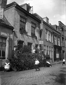 66179 Gezicht op het logement Het Oranjehuis (Oranjestraat 55) te Utrecht met voor het huis, zittend op een stoel, ...